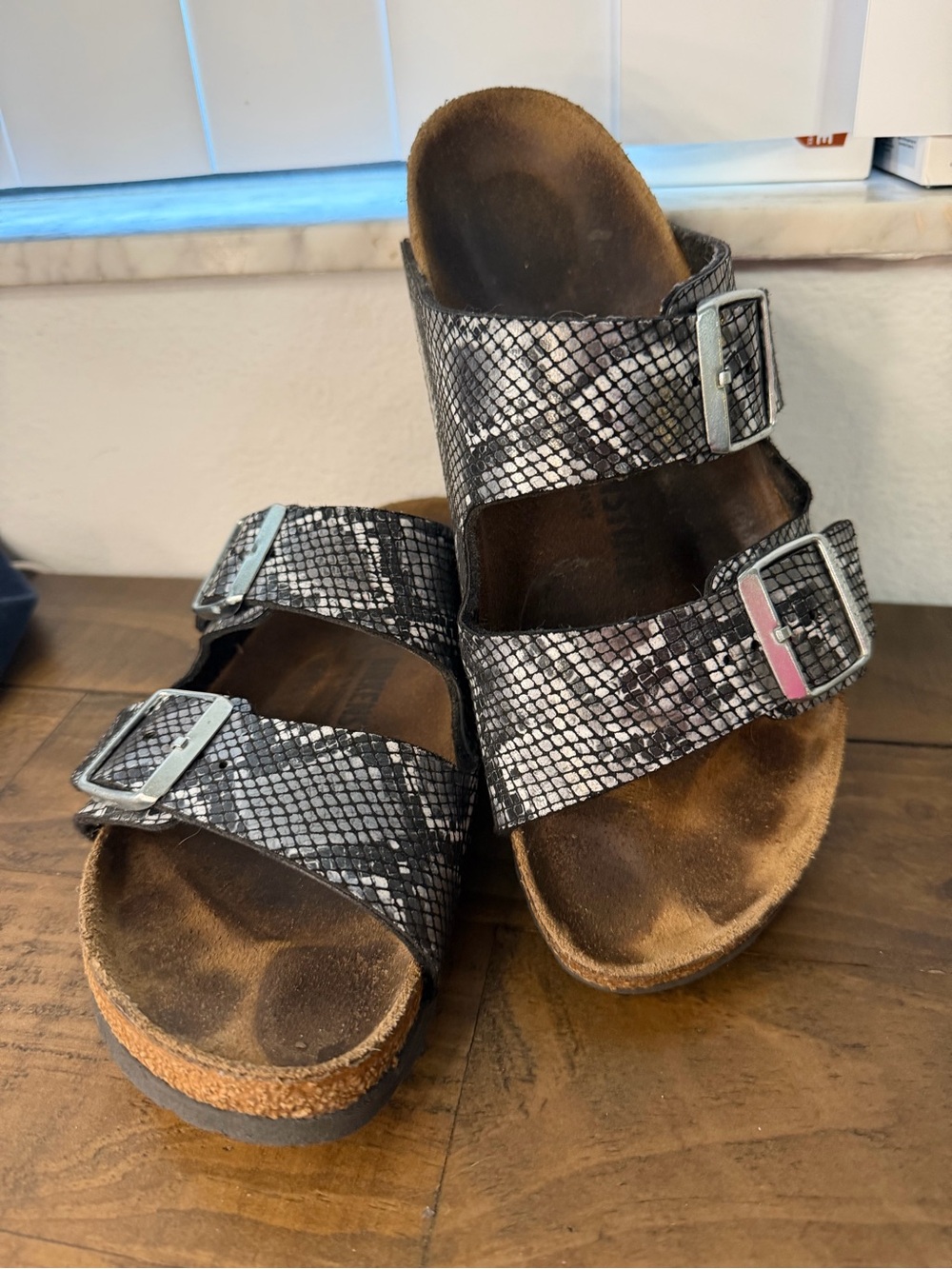 Birkenstock Arizona sandals featuring a shiny black and silver snake print 8